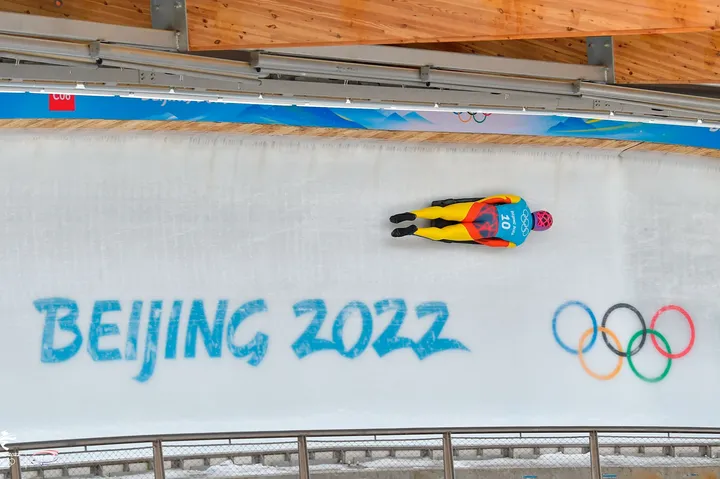 Vista cenital de Ander Mirambell en la pista, sobre el muro con el rótulo Beijing 2022 y los aros olímpicos